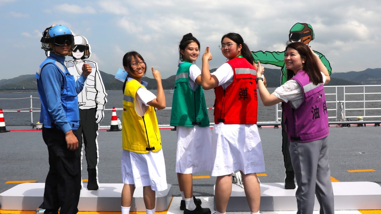 Aircraft carrier ‘rainbow-men’ add splash of colour to Hong Kong pupils’ visit